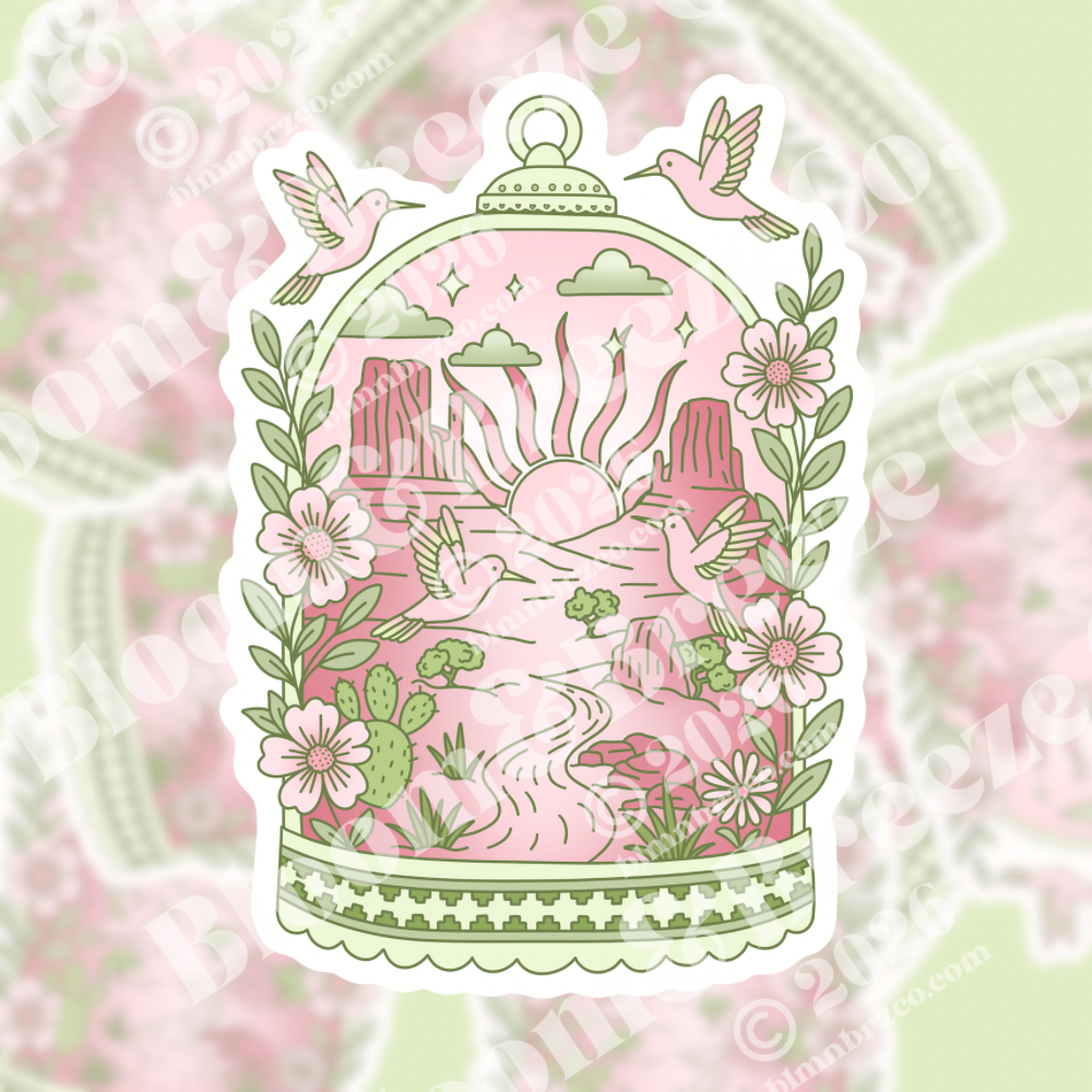 Romantic desert birdcage sticker with pink Monument Valley sunrise, hummingbirds, and wildflowers.