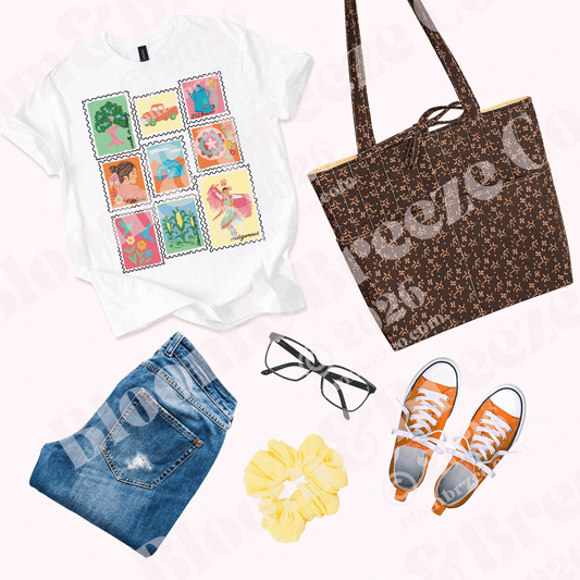 Flat lay outfit featuring a white graphic T-shirt with colorful vintage-style stamp illustrations, styled with blue jeans, orange sneakers, black glasses, a yellow scrunchie, and a brown floral quilted tote bag.