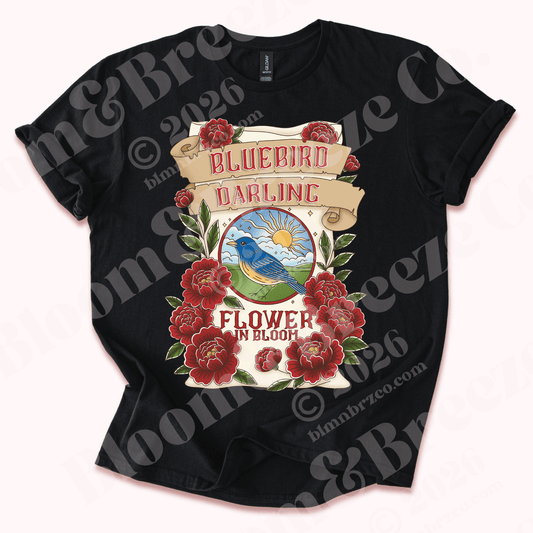 Black t-shirt with 'Bluebird Darling Flower in Bloom' design, depicting the navajo favorite baking flour bag, bluebird flour, with red peonies blooming around bag on a white background