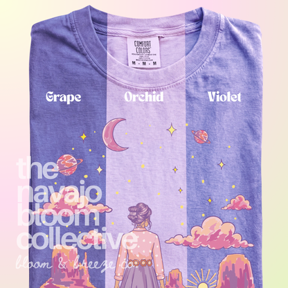 Starry Eyed Dreamer woman, desert mesas, moon, and planets design on a Comfort Colors tee, comparing Grape, Orchid, and Violet.