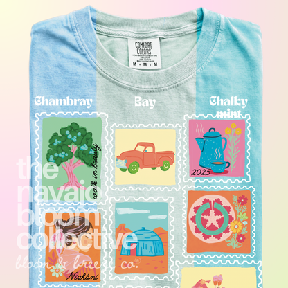Dear Nizhóní stamp-style artwork on a folded Comfort Colors tee, comparing Chambray, Bay, and Chalky Mint.