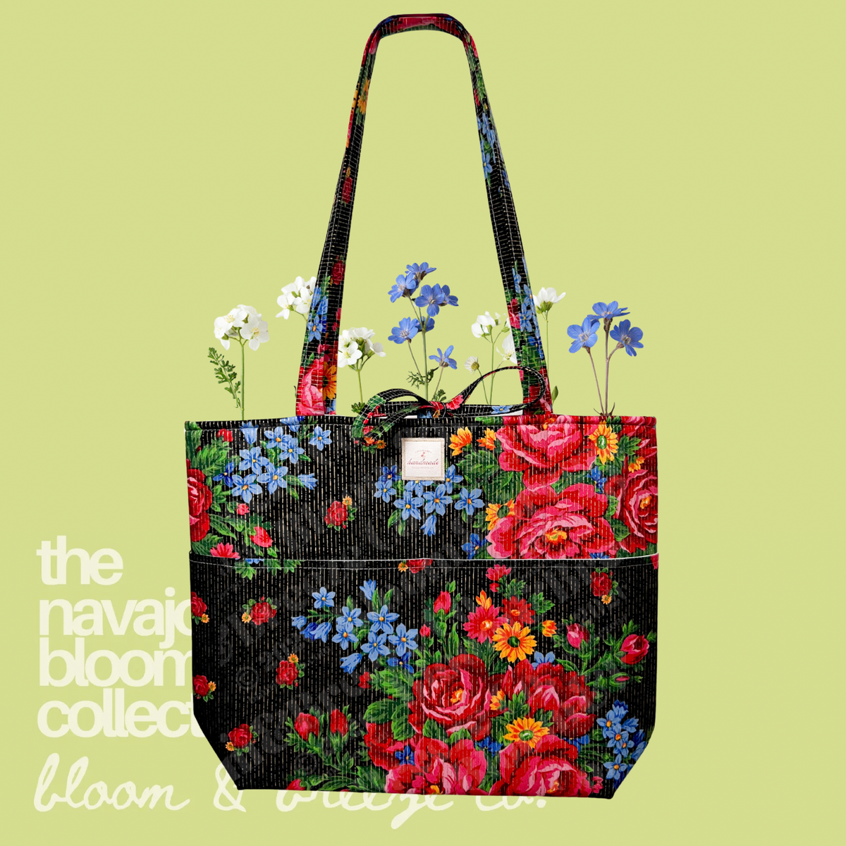 Black floral quilted tote bag with red, blue, and yellow flowers on a soft green background.