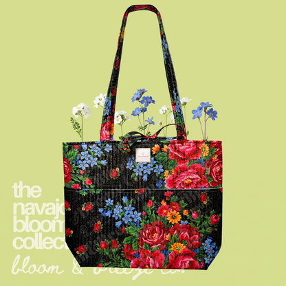Black floral quilted tote bag with red, blue, and yellow flowers on a soft green background.