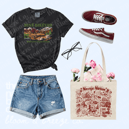 Outfit flat lay on light blue background with   Black vintage t-shirt, shorts, maroon shoes and canvas tote