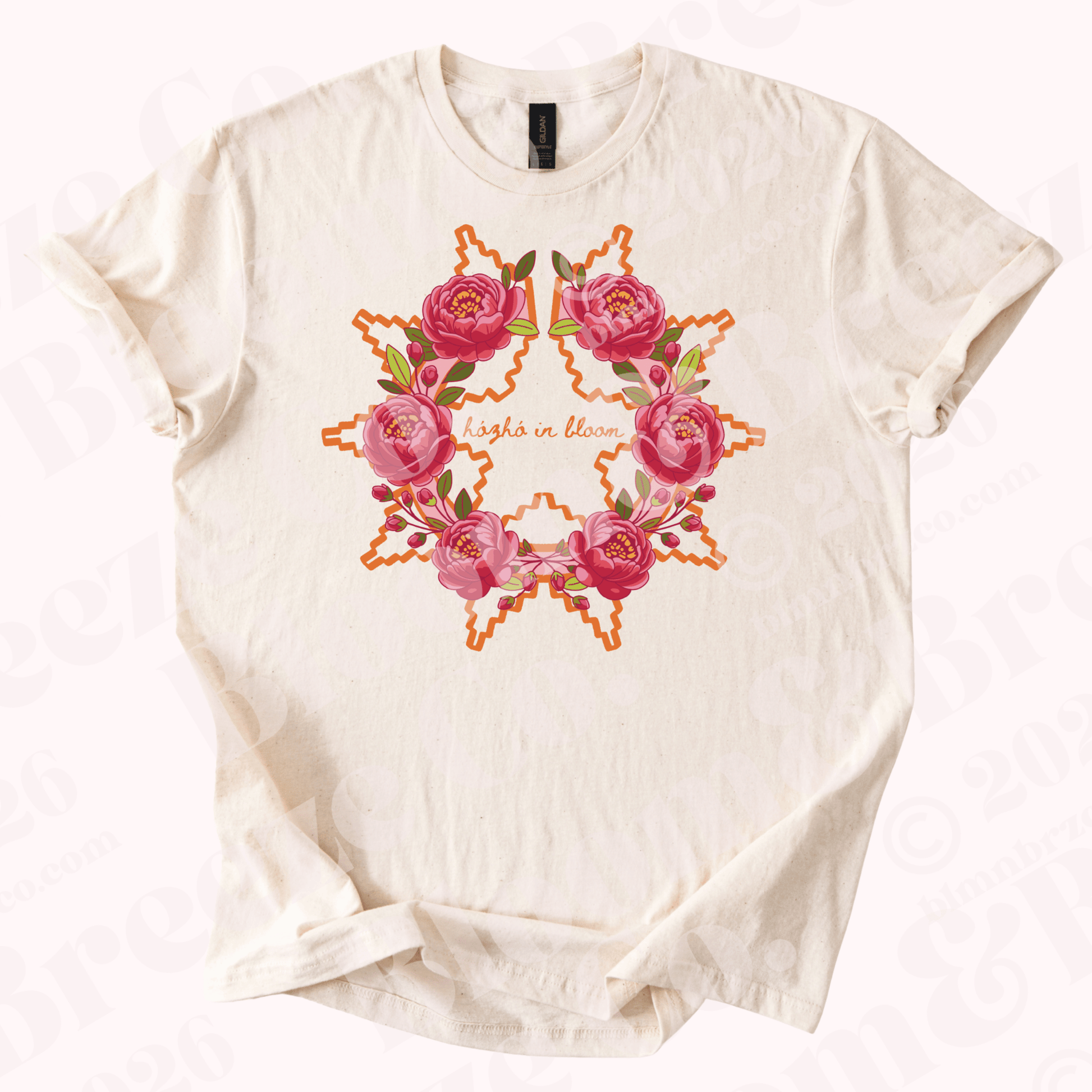 Beige t-shirt with Navajo wedding basket inspired design with peonies and text “Hozho in bloom” on a white background
