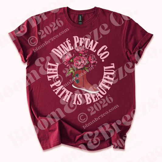 Maroon t-shirt with traditional navajo moccasin with peonies blooming from moccasin design and text reading Diné petal co, the path is beautiful on a white background