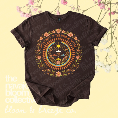 Brown Great Seal of the Navajo Nation graphic tee with floral details on a soft yellow floral background.