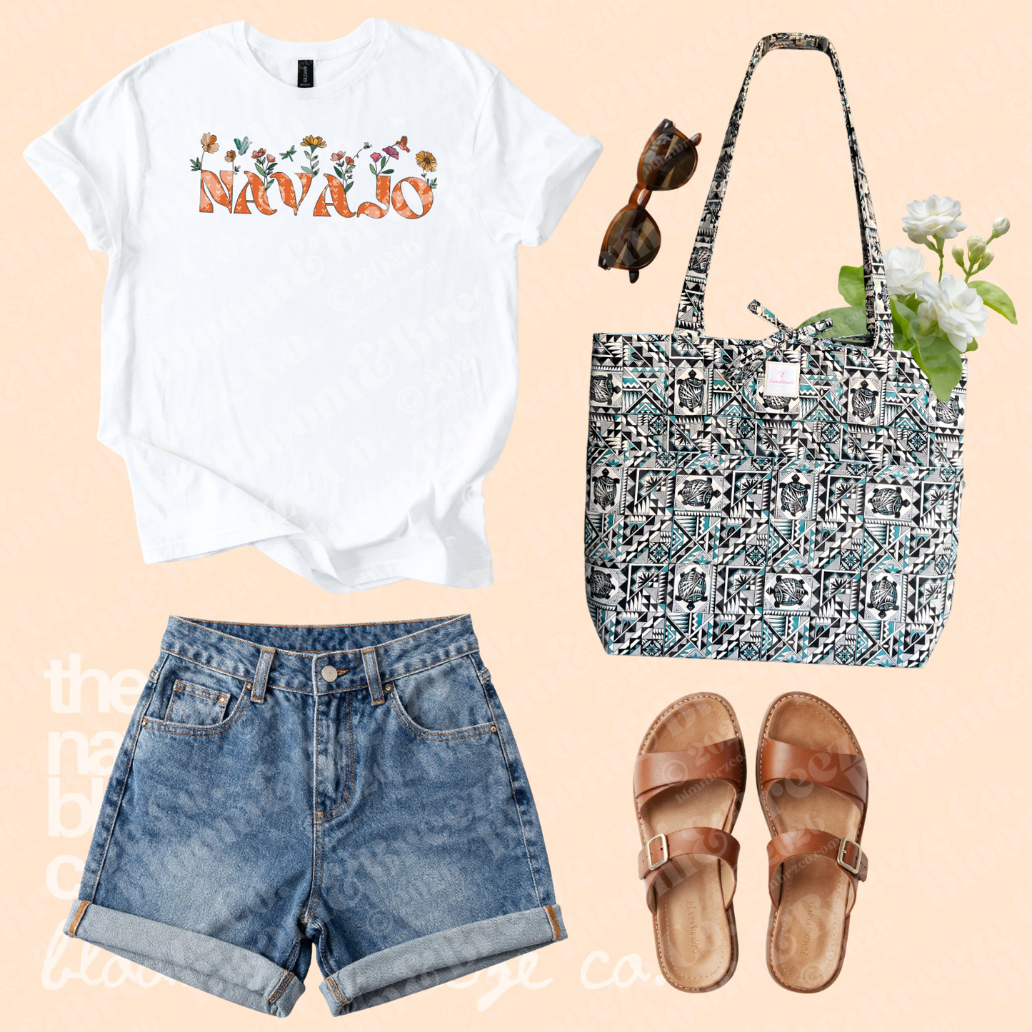 White Navajo floral graphic tee styled with denim shorts, brown sandals, sunglasses, and a black-and-turquoise quilted tote bag.