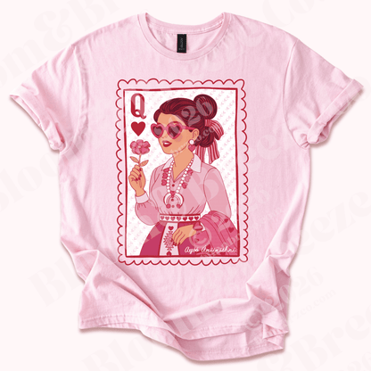 Pink t-shirt with a graphic design of a navajo cartoon woman holding a flower, wearing heart squash blossom, matching pink monochrome navajo traditional outfit on a white background