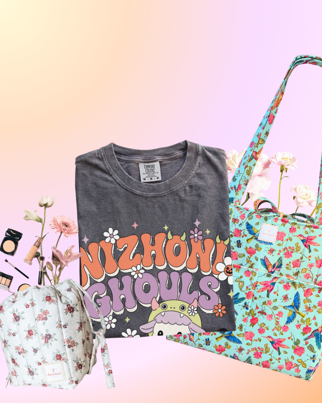 A styled flat-lay featuring a dark gray graphic t-shirt with 'NIZHON! GHOULS' text, alongside two floral tote bags and a matching floral drawstring pouch, arranged with flowers against a pastel gradient background.