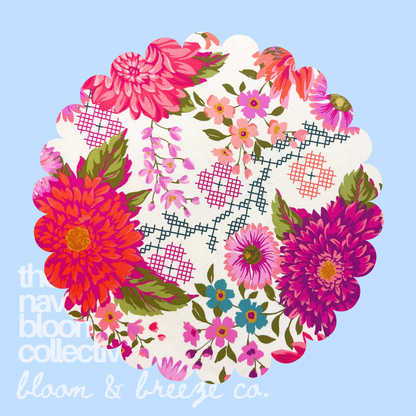 Cream fabric swatch with bright pink, orange, purple, blue, and green floral print on a soft blue background.