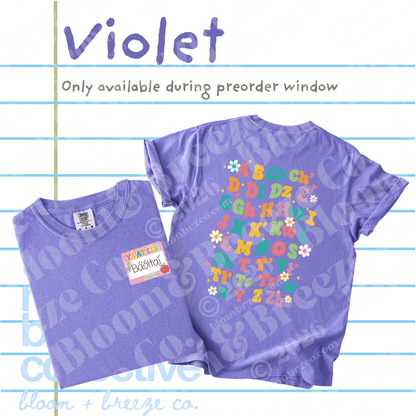 Two purple short-sleeve T-shirts shown on a lined white background with the word 'Violet' and preorder text. One shirt is folded and shows a small name tag in navajo writing 
