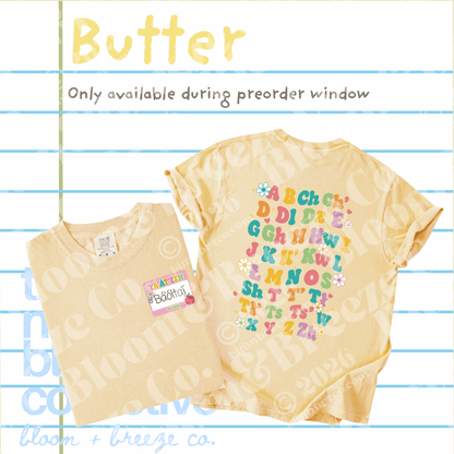 Two pale butter-yellow short-sleeve T-shirts shown on a lined-paper background with text reading 'Butter' and 'Only available during preorder window.' One shirt is folded and shows a small front label; the other is laid flat and shows a large multicolor alphabet print on the back with small flower motifs.