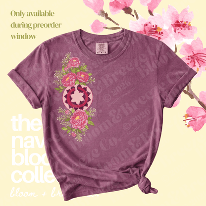 A mauve-purple short-sleeve t-shirt with a pink floral and circular graphic on the front, styled with a knot at the hem against a pale yellow background with cherry blossom graphics and text overlays.