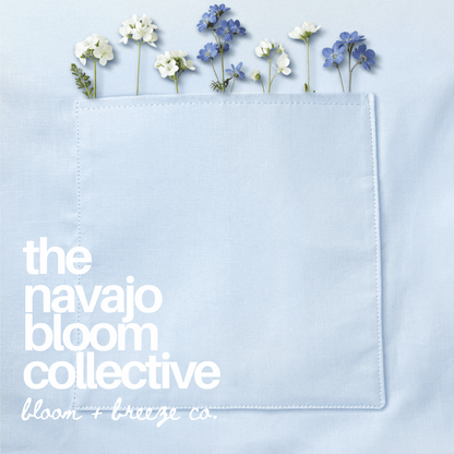 Close-up of a pale blue pocket decorated with delicate pink and white flowers, featuring “The Navajo Bloom Collective” branding.