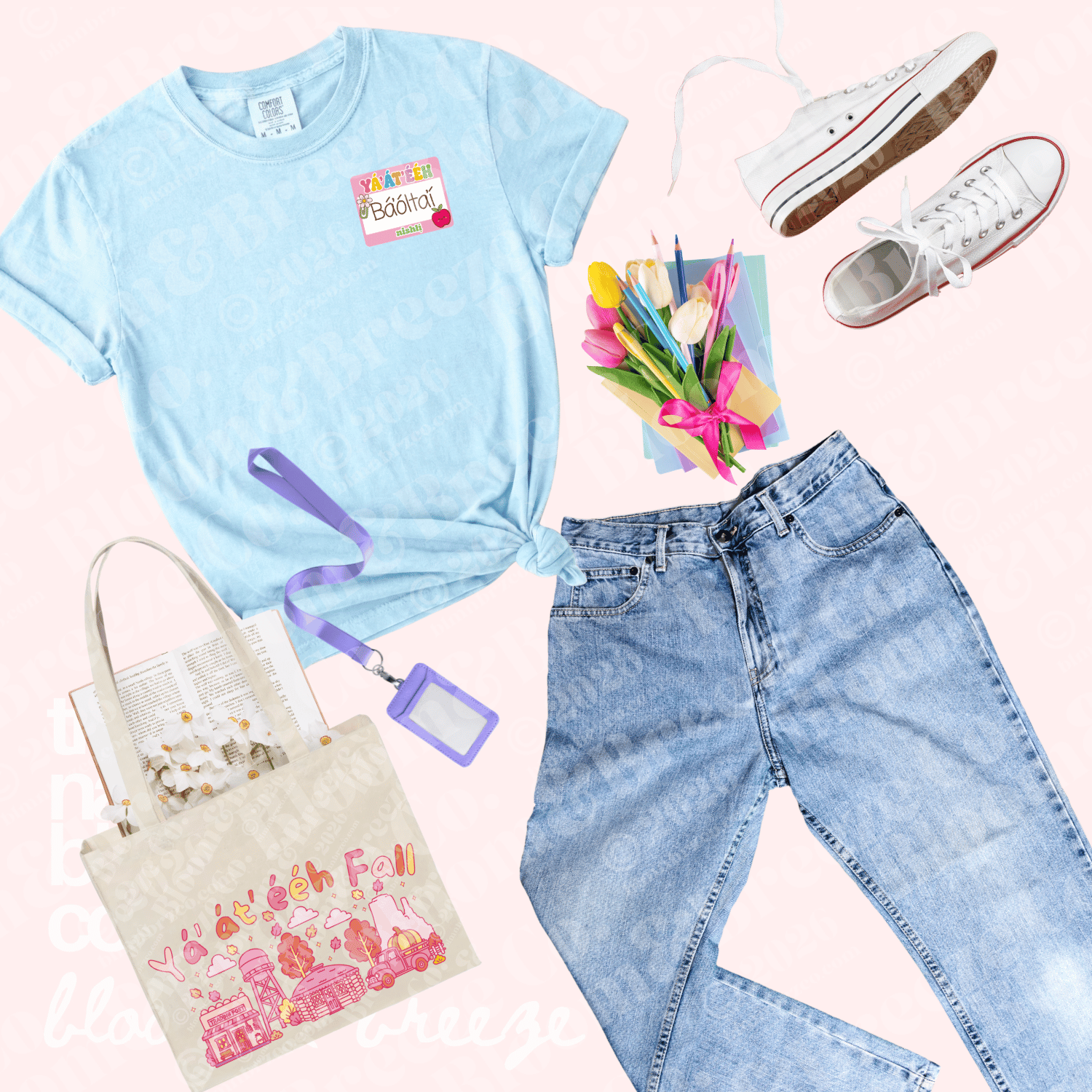 A styled flat-lay outfit featuring a light blue graphic t-shirt with a ya’at’eeh I’m the teacher patch, light-wash blue jeans, white canvas sneakers, a beige tote bag with a pink graphic, a purple lanyard, and a small bouquet of tulips, all arranged on a pale pink background.