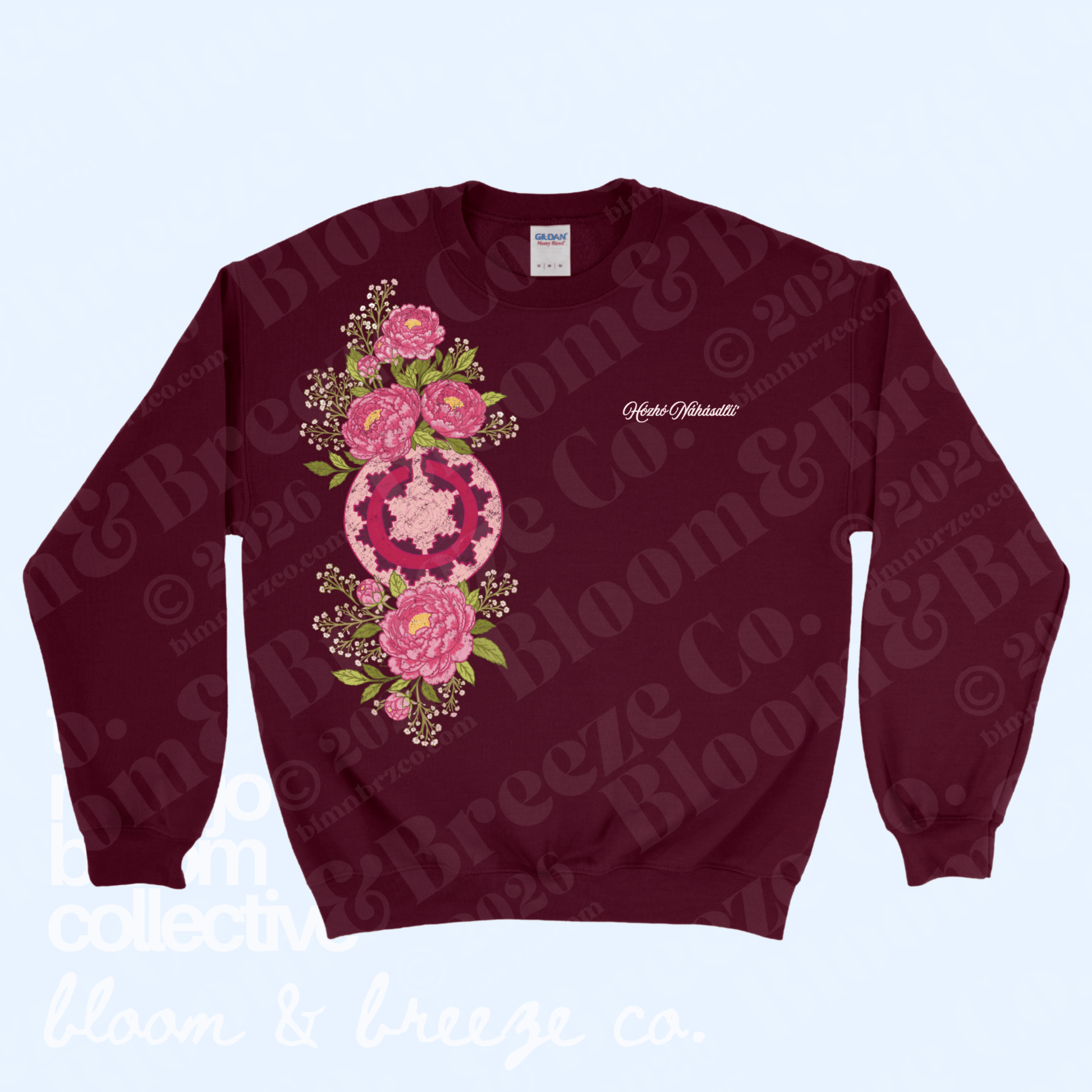 A maroon crewneck sweatshirt featuring a large pink and green floral mandala graphic on the front, with 'Catherine Barnett' printed in white script on the left chest. The sweatshirt is displayed flat against a light blue background with a faint repeating watermark.
