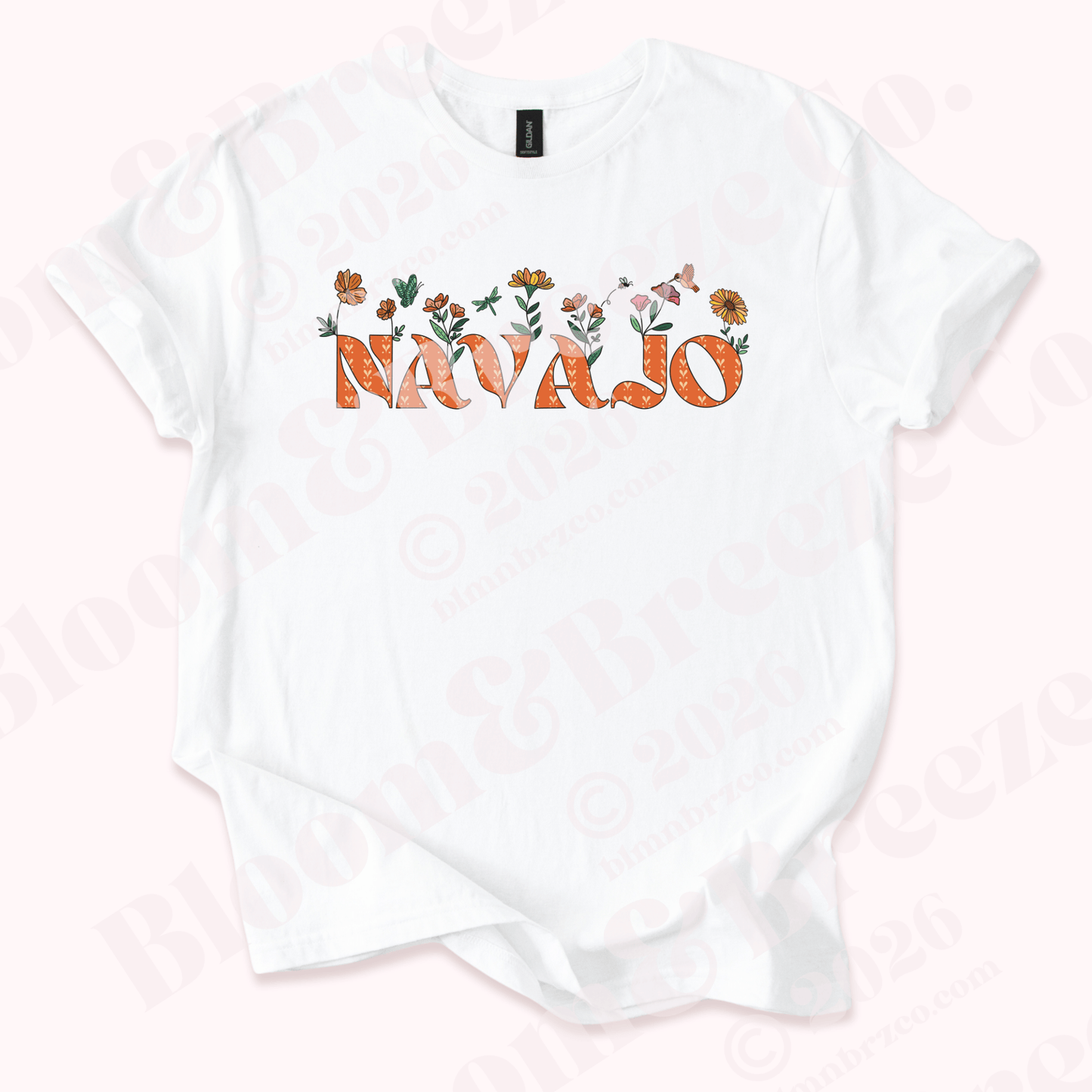 White t-shirt with 'Navajo' text and floral designs on a light pink background