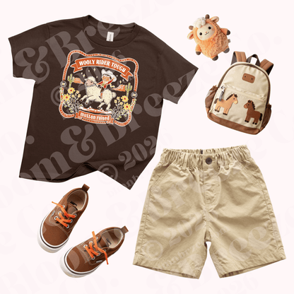 Youth brown graphic t-shirt with ‘Wooly Rider Tough – Mutton Raised’ design styled with khaki shorts, brown sneakers, small backpack, and plush lamb.