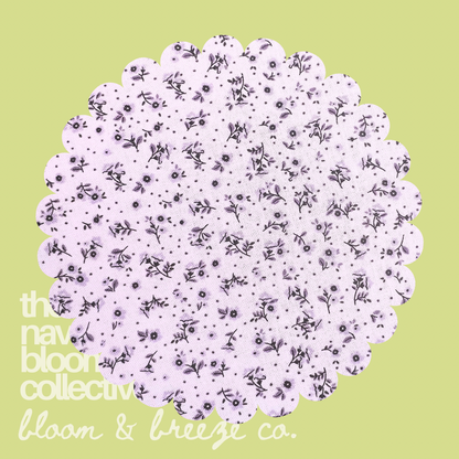 Light lilac fabric swatch with tiny dark floral print on a soft green background with Bloom & Breeze Co. branding.