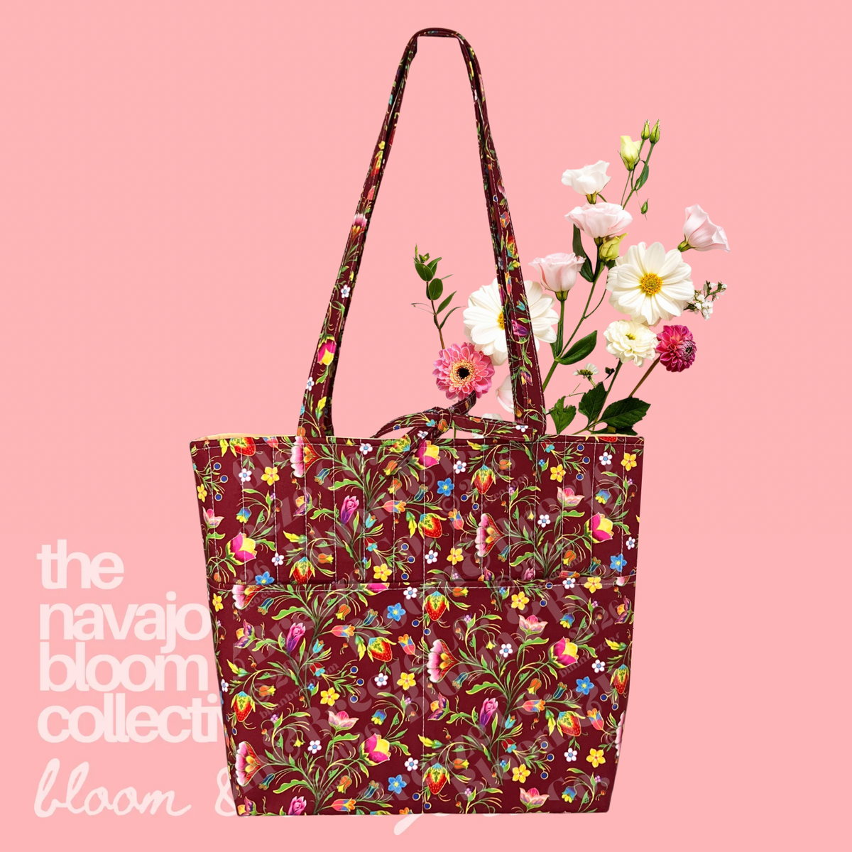 Burgundy floral quilted tote bag with long straps, front pockets, and flowers on a soft pink background.