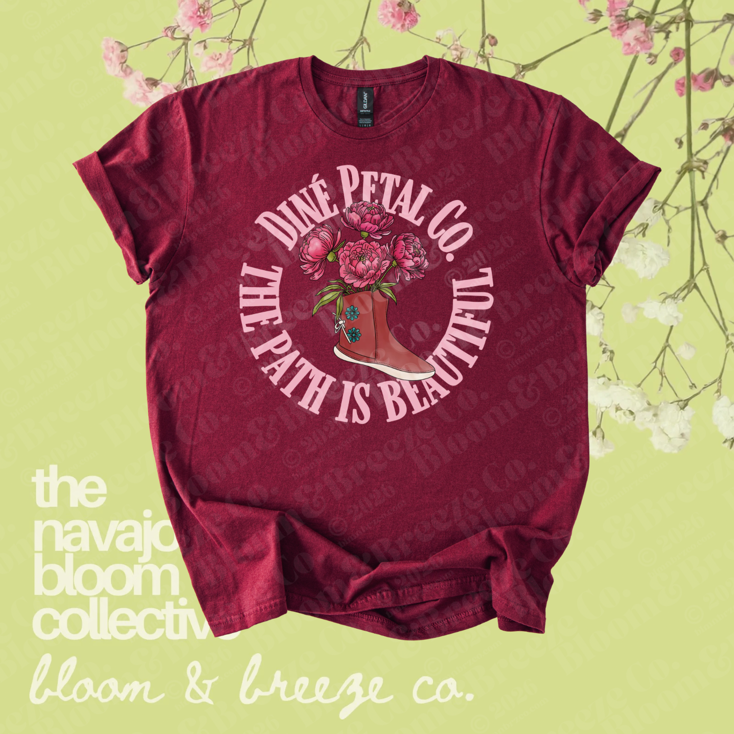 Maroon graphic tee with a floral boot design and “Diné Petal Co. Life Path is Beautiful” text on a soft green floral background.