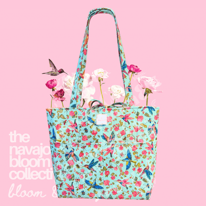 Floral tote bag with flowers on a pink background, featuring 'the navajo bloom collective’.