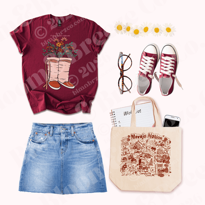 Maroon t-shirt with floral Moccasin design, blue jeans, orange sneakers, glasses, and a tote bag on a white background.